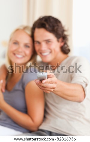 Portrait of a young couple watching TV in their living room
