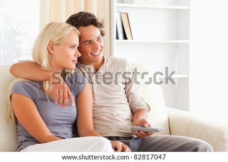 Cute couple watching TV in their living room