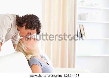 Man kissing his girlfriend on the forehead in their living room