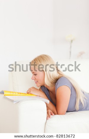 Portrait of a delighted woman reading a magazine in her living room