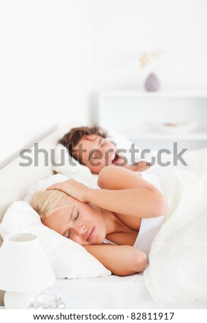 Portrait of an annoyed woman awaken by her boyfriend\'s snoring in their bedroom