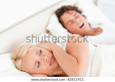 Annoyed woman awaken by her fiance\'s snoring in their bedroom