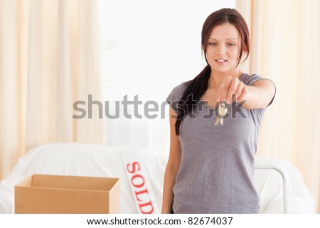 Gorgeous woman holding keys in a living room