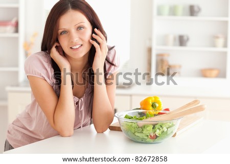 Gorgeous woman using a cellphone in a kitchen