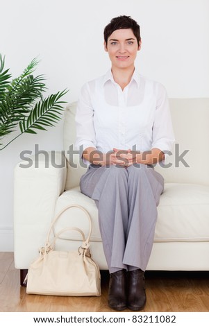 Smiling short-haired woman sitting on a sofa in a waiting room