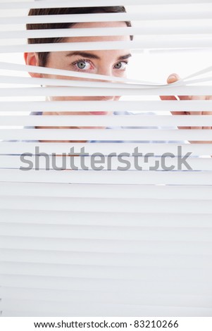 Curious Woman peeking out of a window in an office