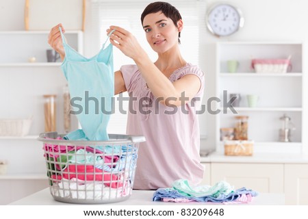 Smiling Woman folding clothes in a utility room