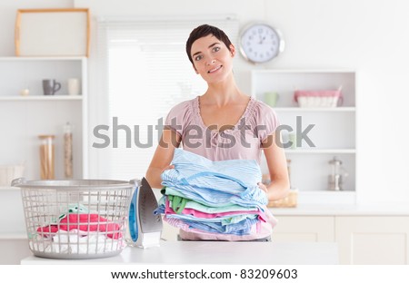 Woman with a pile of clothes in a utility room