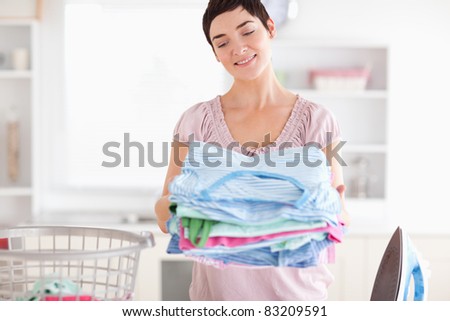 Gorgeous Woman with a pile of clothes in a utility room