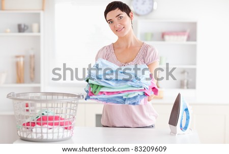 Beautiful Woman with a pile of clothes in a utility room
