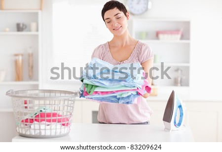 Joyful Woman with a pile of clothes in a utility room