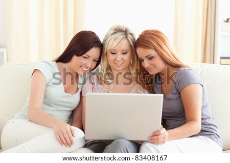 Cute women lounging on a sofa with a laptop in a living room