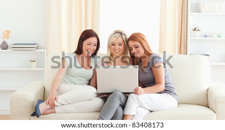 Gorgeous women lounging on a sofa with a laptop in a living room