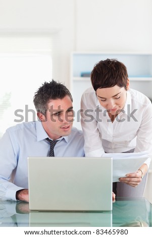 Portrait of colleagues comparing a blueprint document to an electronic one in an office