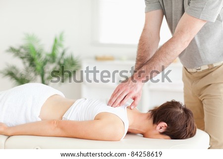 A masseur is massaging a female customer\'s back