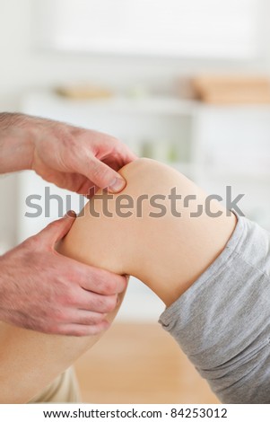 Guy massaging a woman\'s knee in a room