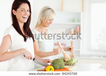 Laughing Women preparing dinner in a kitchen