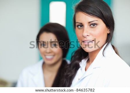 Beautiful female scientists posing with the camera focus on the foreground
