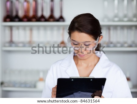 Scientist writing on a clipboard in a laboratory