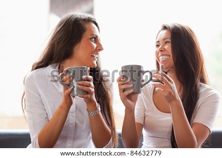 Laughing friends having a coffee in a cafe