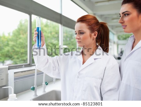 Science students looking at a graduated cylinder in a laboratory