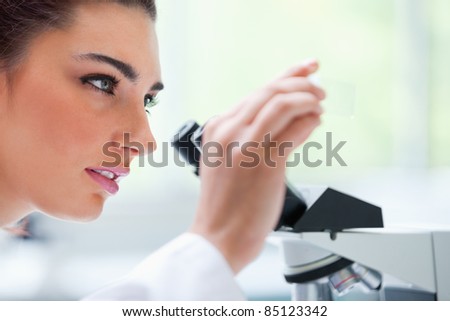 Young woman looking at a microscope slide in a laboratory