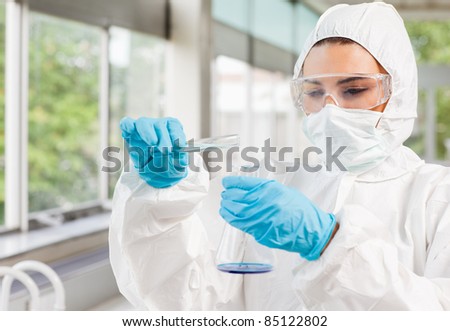 Protected scientist pouring liquid in a laboratory