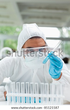 Portrait of a protected serious scientist holding a test tube in a laboratory