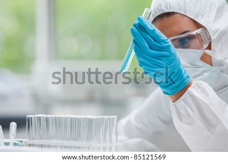 Protected science student holding a test tube in a laboratory