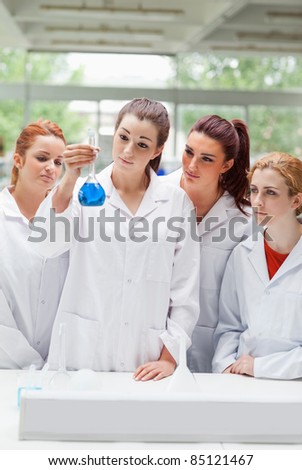Portrait of science students looking at a flask in a laboratory