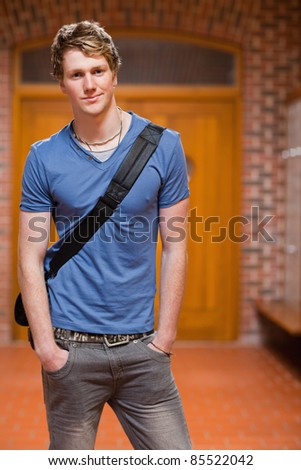 Portrait of a handsome student standing up in a corridor