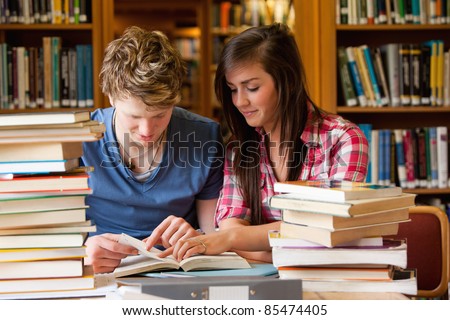 Serious students looking at a book in a library