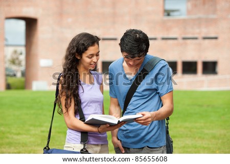 Couple reading a book outside a building