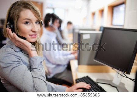 Smiling blonde operator posing with a headset in a call center