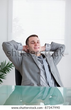 Close up of young businessman relaxing sitting behind a table