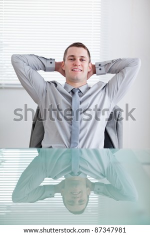 Businessman sitting back behind a table