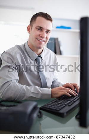 Happy young businessman working on his computer