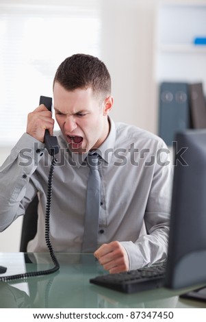 Angry young businessman on the phone