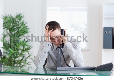 Disappointed businessman getting sad news on the phone