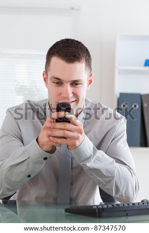 Smiling businessman getting a pleasant text message