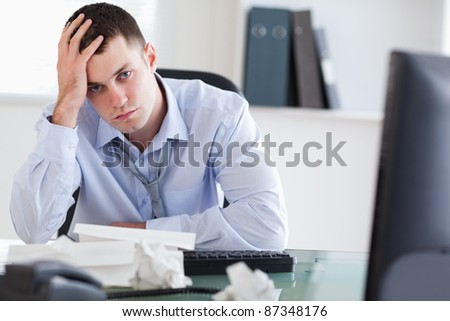 Close up of frustrated young businessman doing his accounting