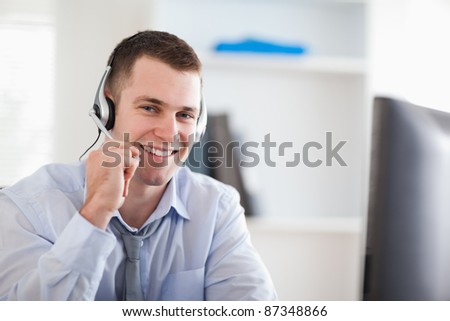 Smiling young call center agent speaking with costumer