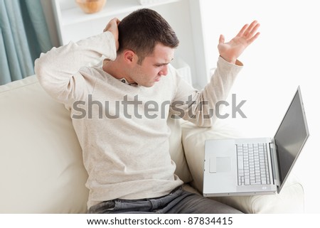 Lost man using a laptop in his living room
