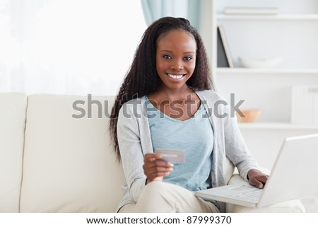 Smiling woman shopping online in living room