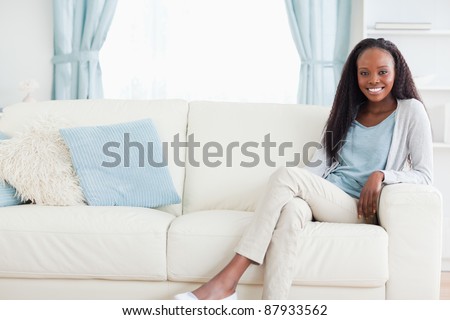Smiling woman leaning back on sofa