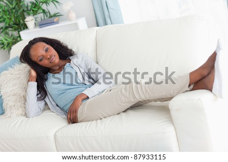 Young woman on sofa putting her feet up