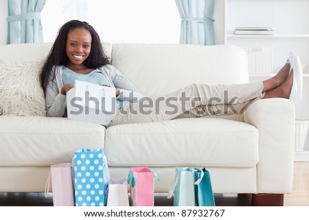 Smiling young woman putting her feet up after shopping