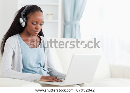 Young woman with headphones on working on laptop
