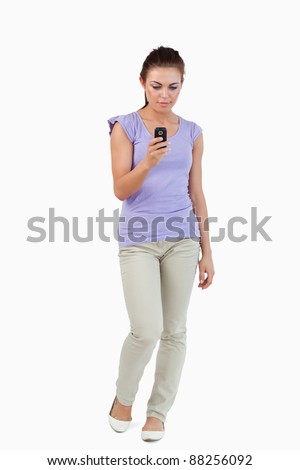 Young female writing text message against a white background