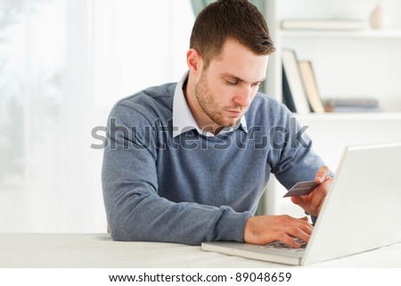 Young male entering credit card information in his laptop
